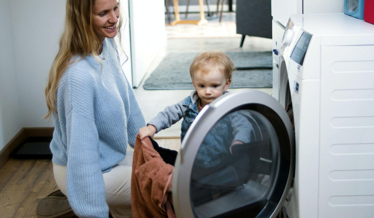 Mujer y niño frente a una lavadora reparada